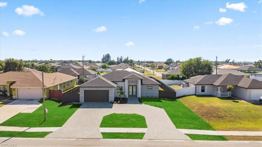 View of front of home featuring a residential view, driveway, an attached garage, and a shingled roof