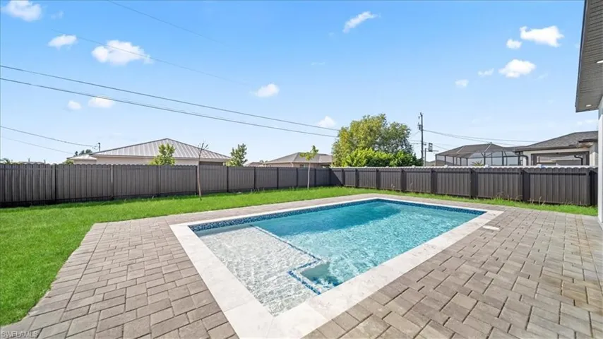 View of pool featuring a fenced backyard and patio surround