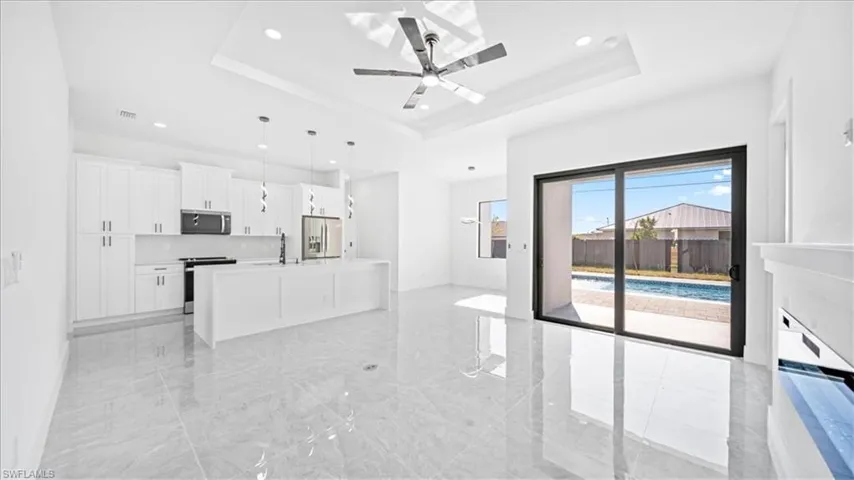 Unfurnished living room with a ceiling fan, recessed lighting, and light marble finish flooring