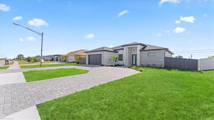 View of front of house with driveway, stucco siding, and an attached garage