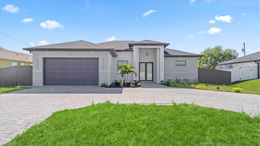 Prairie-style home with stucco siding, a gate, decorative driveway, and a garage