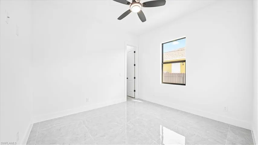 Spare room with baseboards and a ceiling fan