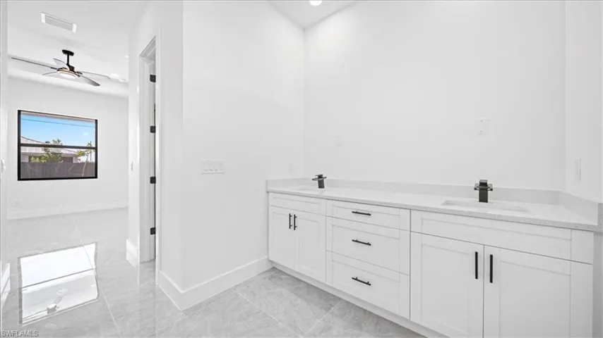 Full bathroom with double vanity, recessed lighting, and a ceiling fan