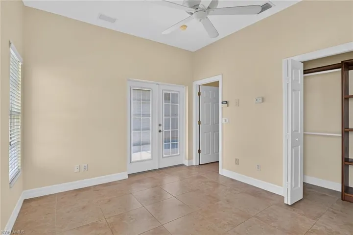 Casita with a central paddle fan, tile flooring, glass-paneled double doors, and a built-in closet unit