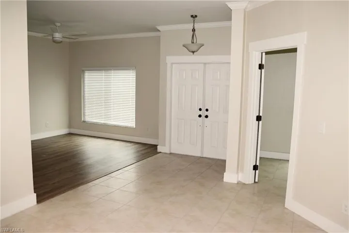 Entryway featuring ceiling fan, ornamental molding, and light tile patterned floors