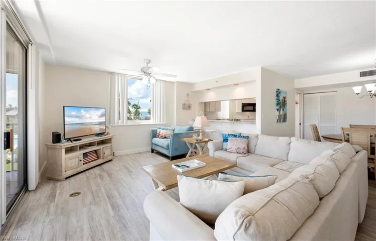 Living area with light wood-type flooring, a chandelier, and a ceiling fan