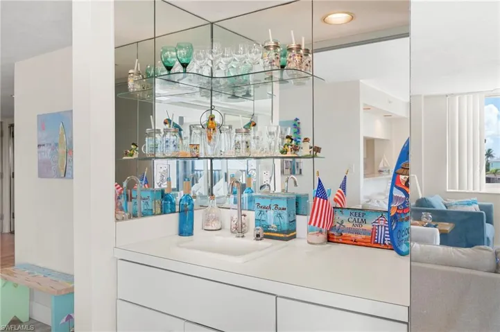 Indoor wet bar with white cabinetry and light countertops