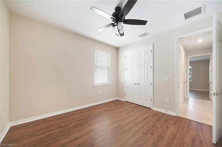 Unfurnished bedroom with wood-style flooring, ceiling fan, and a closet