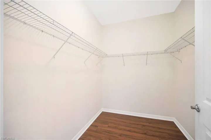 Primary Bedroom Walk in closet featuring wood style floors