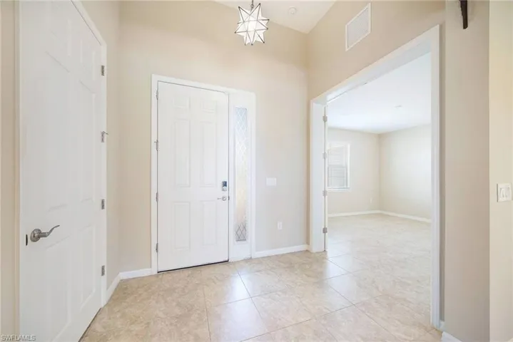 Foyer with baseboards and light tile flooring
