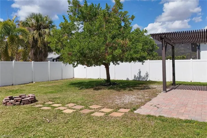 Fenced backyard with a pergola and a patio