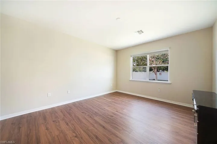 Primary Bedroom featuring wood-style flooring and a large window