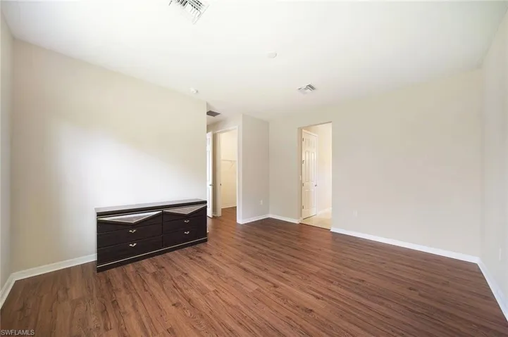Primary Bedroom with baseboards and  wood style floors