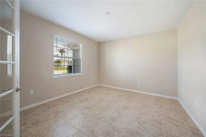 Large Office or Den with Glass French Doors, a large window and light tile floors