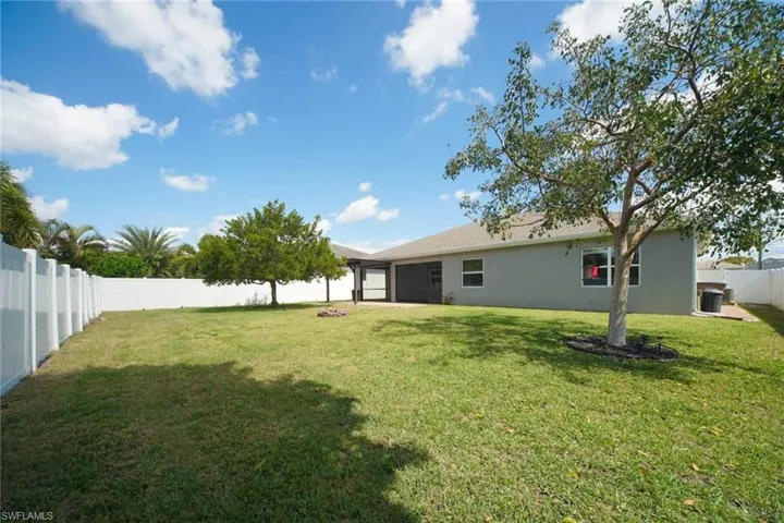 Back of house with a fenced backyard and stucco siding