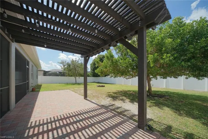 Fenced backyard with a pergola and and an extended paver patio area