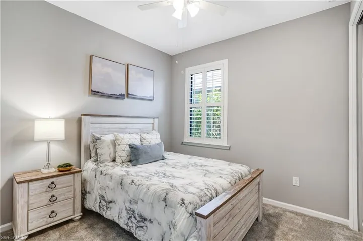Carpeted bedroom with baseboards and ceiling fan