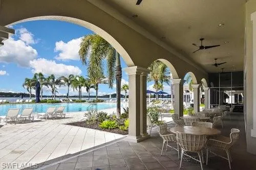 View of patio with ceiling fan and a community pool