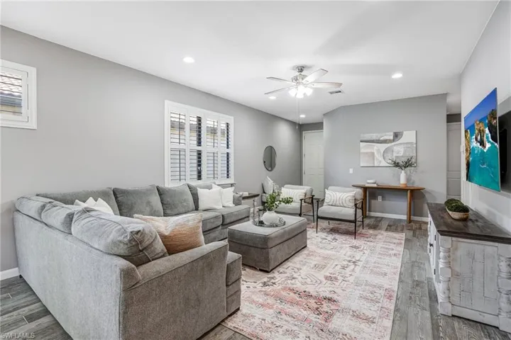 Living area with ceiling fan, wood finished floors, plenty of natural light, recessed lighting, and baseboards
