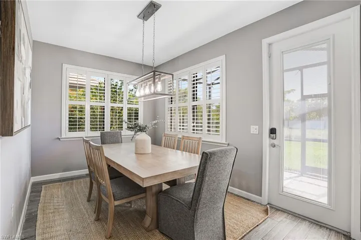 Dining room with wood finished floors, baseboards, and healthy amount of natural light
