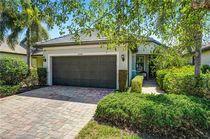View of front facade with stucco siding, an attached garage, and driveway