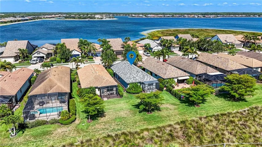 Aerial perspective of suburban area featuring a large body of water and a pool