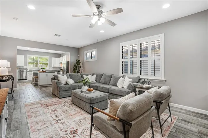 Living room with healthy amount of natural light, recessed lighting, light wood-style flooring, and ceiling fan