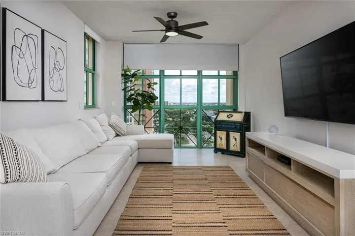 Living room with ceiling fan and expansive windows