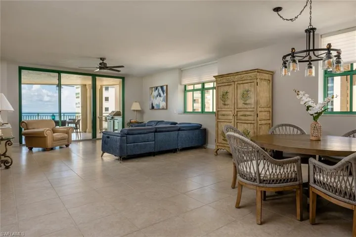 Dining space featuring ceiling fan, light tile patterned floors, and floor to ceiling windows
