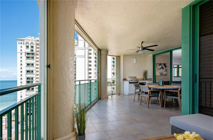 Balcony featuring outdoor dining space, a ceiling fan, a water view, and grilling area