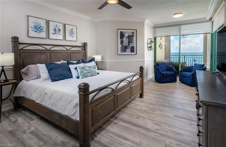 Bedroom with ornamental molding, access to outside, light wood-style floors, a ceiling fan, and expansive windows