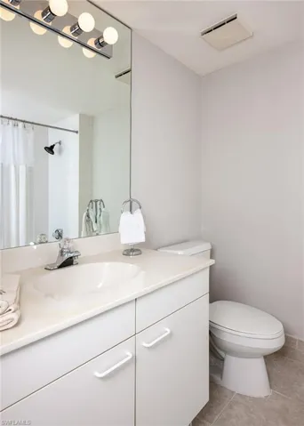 Full bathroom featuring vanity, a shower with shower curtain, and light tile patterned floors