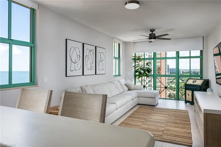 Living area with a ceiling fan and light tile patterned flooring