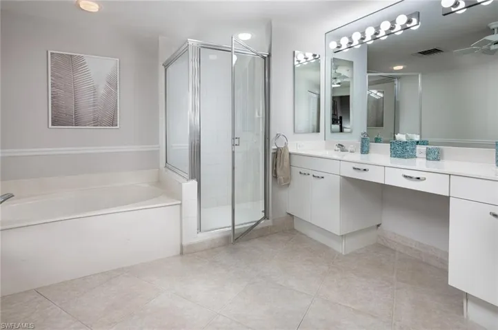 Bathroom with vanity, a stall shower, a bath, and light tile patterned floors
