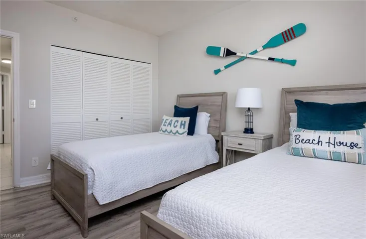Bedroom with wood finished floors and a closet