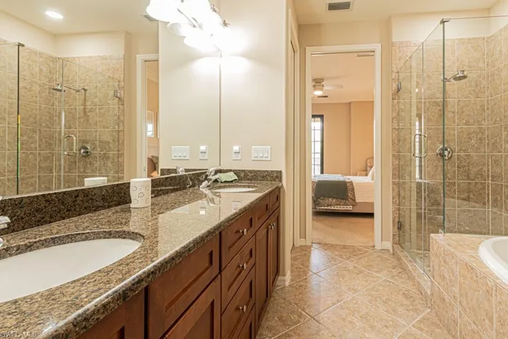 Bathroom with double vanity, tile patterned flooring, separate shower and tub, and ceiling fan