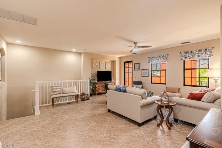 Living room with light tile patterned floors and ceiling fan