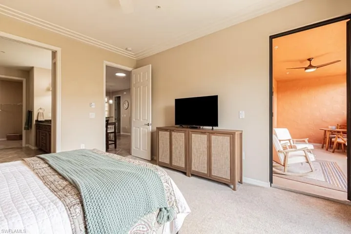 Bedroom with ornamental molding, ceiling fan, and carpet flooring