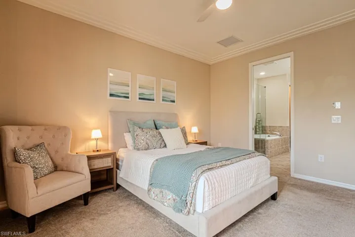 Bedroom with carpet floors, ensuite bath, crown molding, and ceiling fan