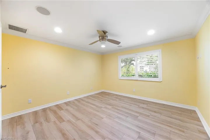 Unfurnished room with a ceiling fan, light wood finished floors, crown molding, and recessed lighting