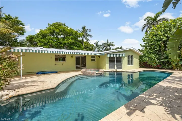 View of swimming pool featuring a patio area and a pool with connected hot tub
