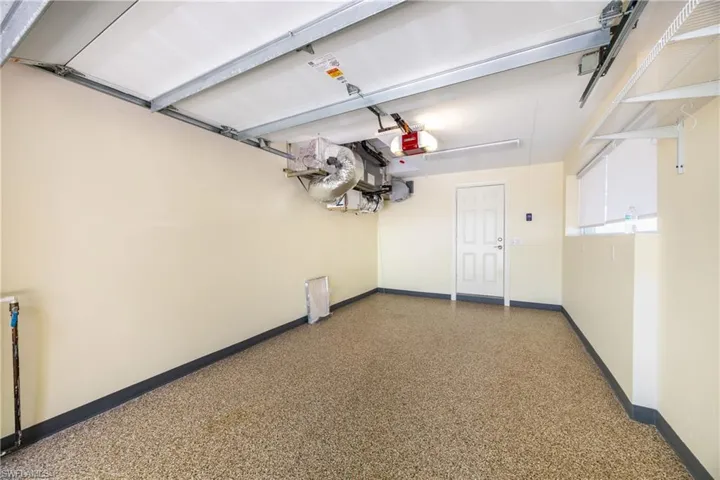 Garage featuring baseboards and a garage door opener