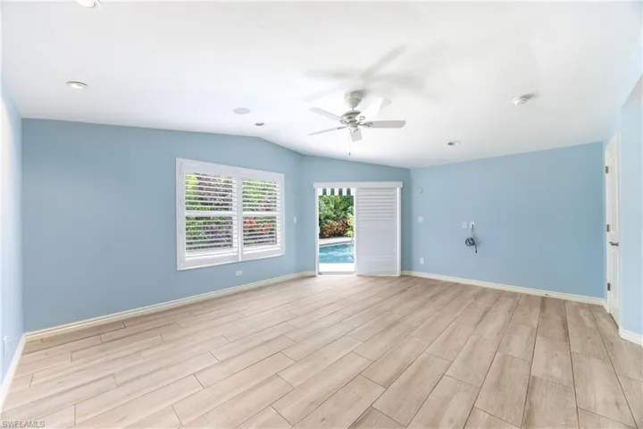 Spare room with a ceiling fan, lofted ceiling, light wood-style floors, a smoke detector, and recessed lighting