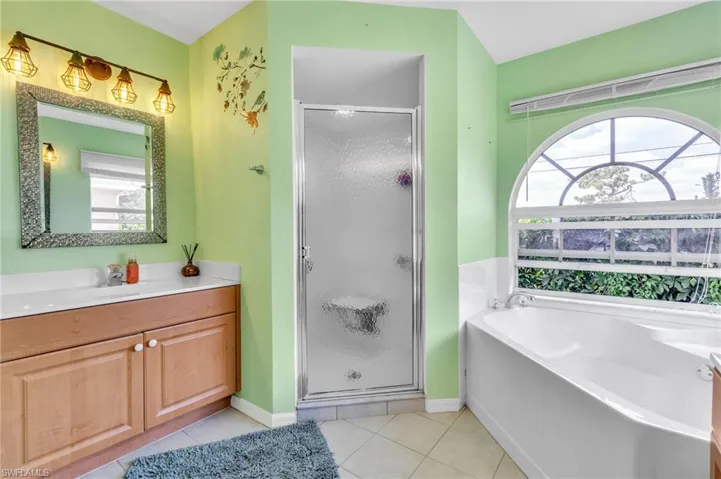 Full bath featuring a shower stall, a bath, and tile patterned floors