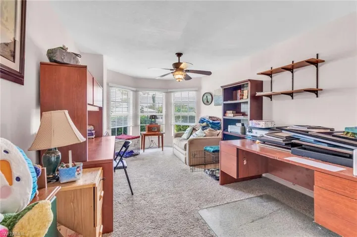 Office space featuring a ceiling fan and light colored carpet