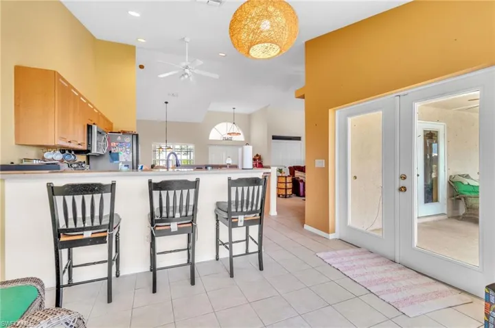 Kitchen with a breakfast bar, a sink, a peninsula, appliances with stainless steel finishes, and ceiling fan