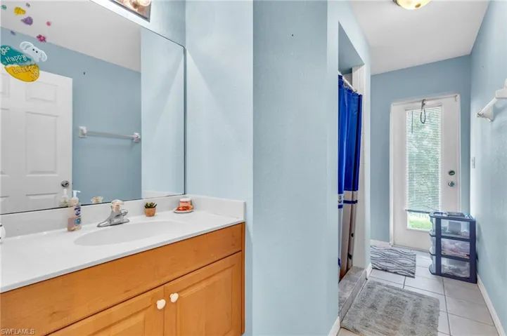 Full bath featuring plenty of natural light, baseboards, vanity, and tile patterned flooring
