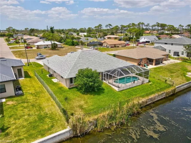 Birds eye view of property with a water view and a residential view