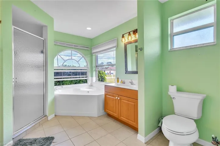 Full bath featuring a shower stall, toilet, and a healthy amount of sunlight