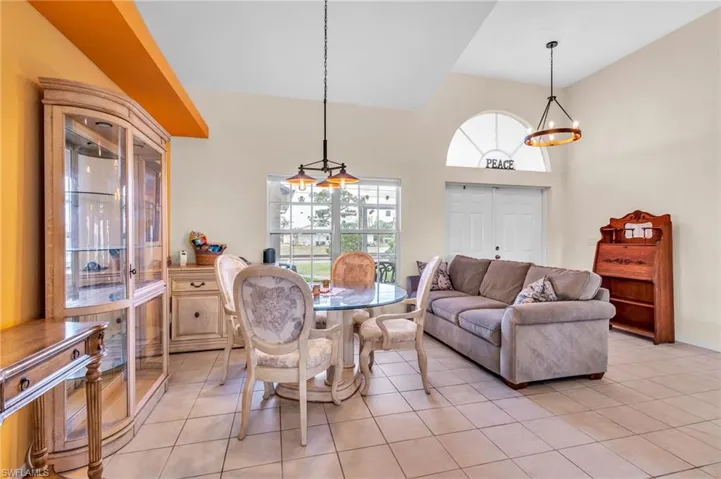 Dining room with a high ceiling, a notable chandelier, and light tile patterned floors